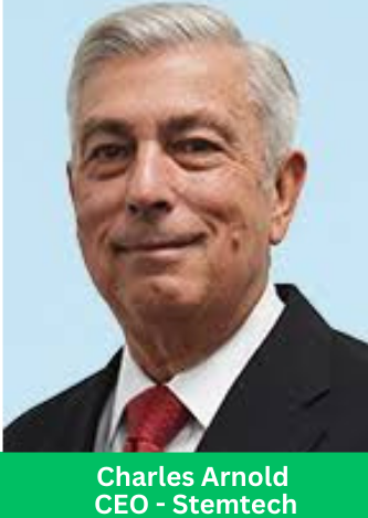 Charles Arnold, CEO of Stemtech, wearing a black suit and red tie, posing for a professional headshot against a light blue background.