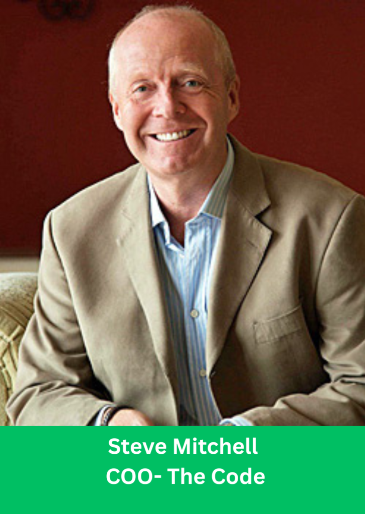 Steve Mitchell - COO of The Code, smiling in a beige blazer sitting on a sofa.