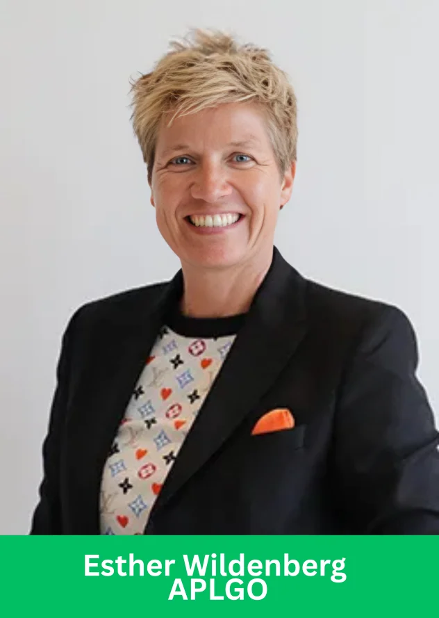 Esther Wildenberg APLGO professional portrait, smiling woman in black blazer with colorful shirt and orange pocket square.
