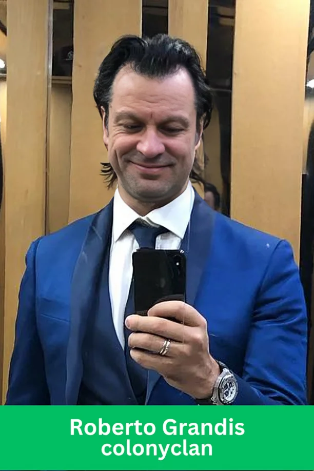 Roberto Grandis, leader at ColonyClan, taking a mirror selfie in a blue suit