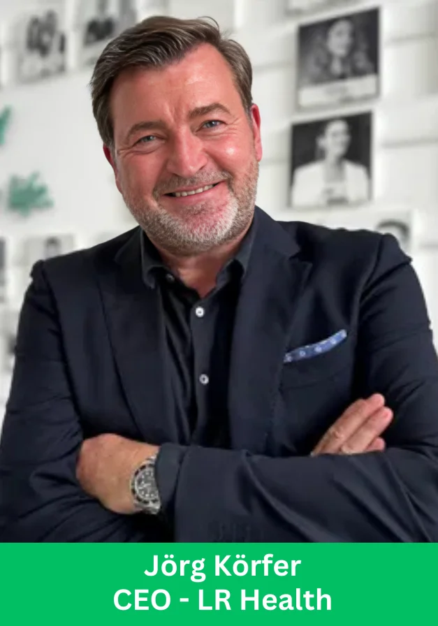Jörg Körfer, CEO of LR Health, smiling with arms crossed in a professional office setting