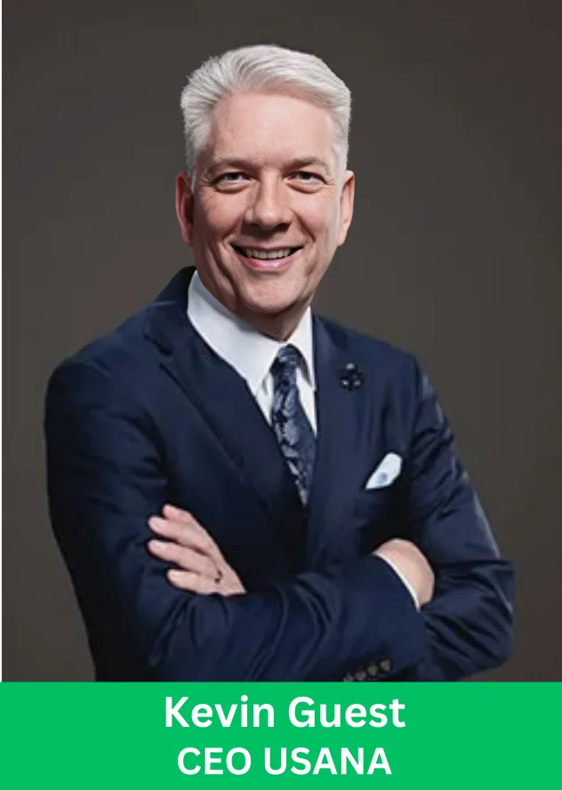 Kevin Guest CEO USANA smiling in a professional navy suit portrait with arms crossed