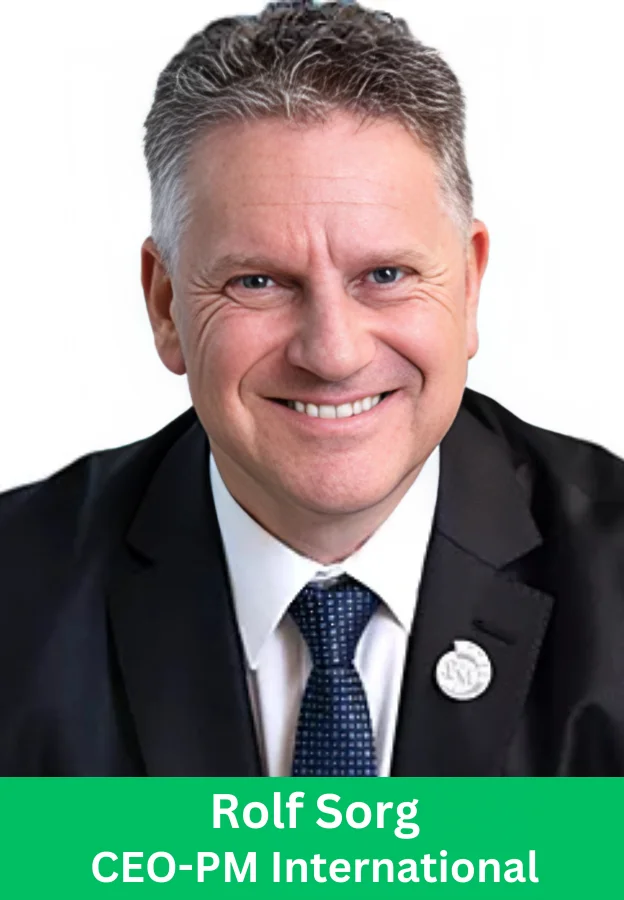 Rolf Sorg CEO PM International smiling in a black suit and blue tie professional headshot