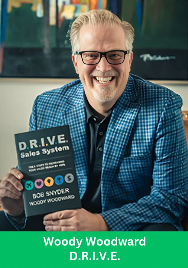 Woody Woodward holding DRIVE System book on leadership and team performance