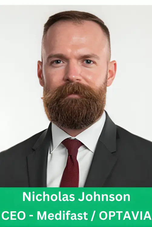 Professional corporate headshot of Nicholas Johnson, CEO of Medifast and OPTAVIA, featuring a full beard, wearing a black suit and red tie.