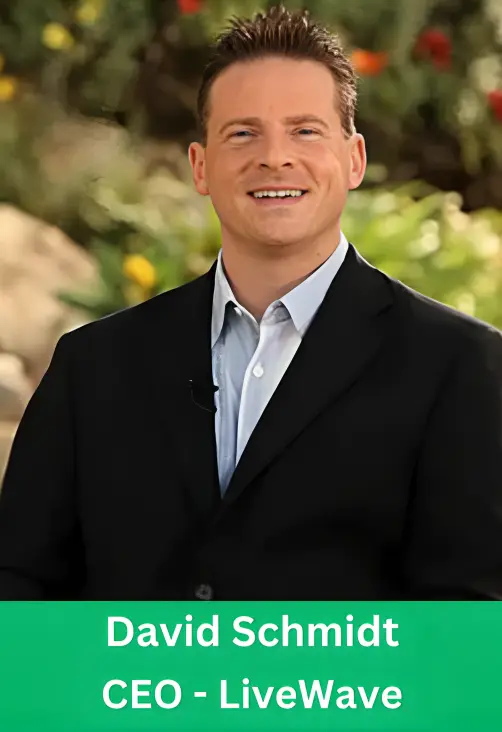 Professional portrait of David Schmidt, CEO of LiveWave, smiling and wearing a black blazer with a light blue shirt against a natural outdoor background.